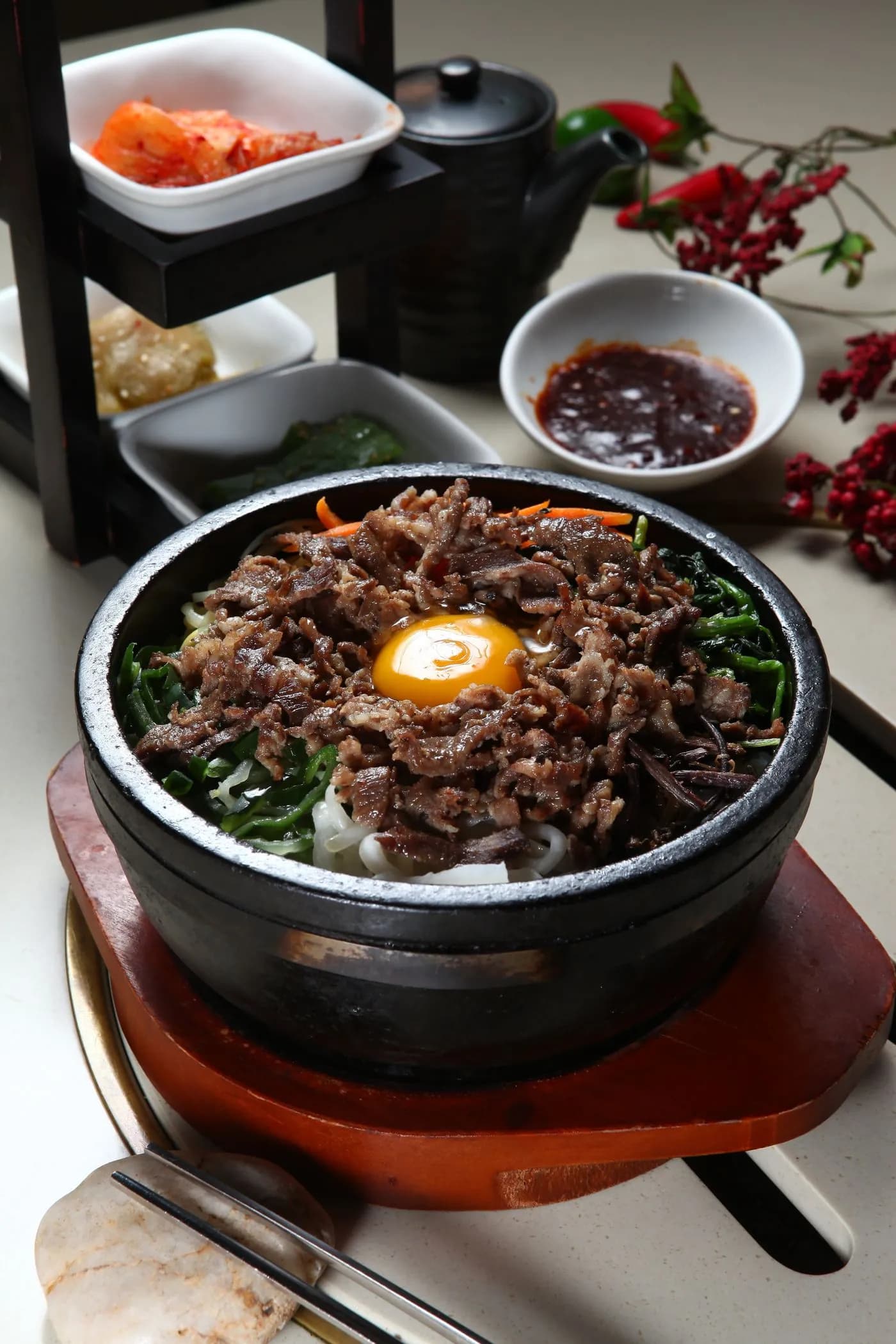 돌솥에 담긴 비빔밥과 반찬 · 매장 예시 사진
